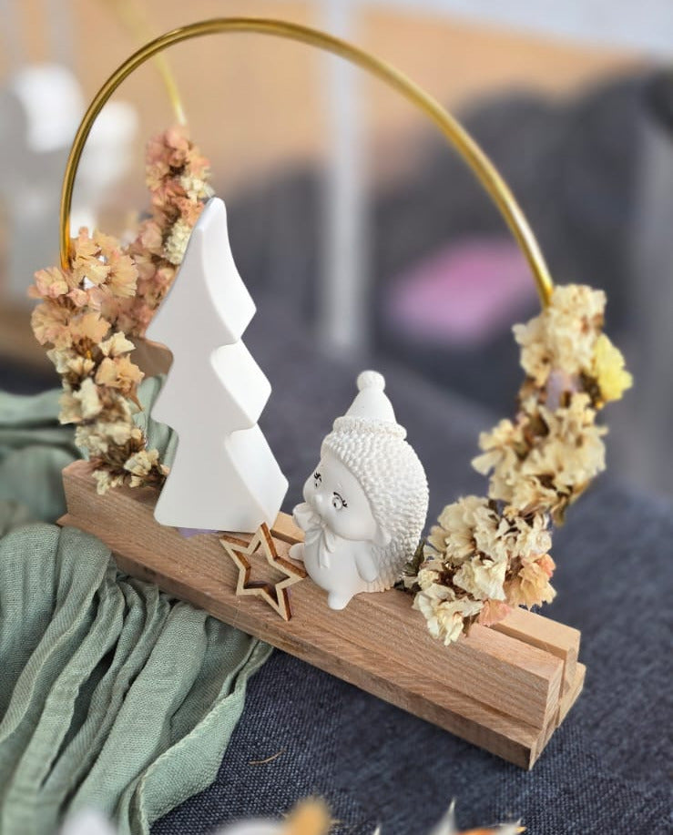 Dekoring-Aufsteller mit goldenem Metallring auf Holzsockel, handgemacht und mit Trockenblumen, weißer Tanne und kleinem Igel – weihnachtliche Tischdeko