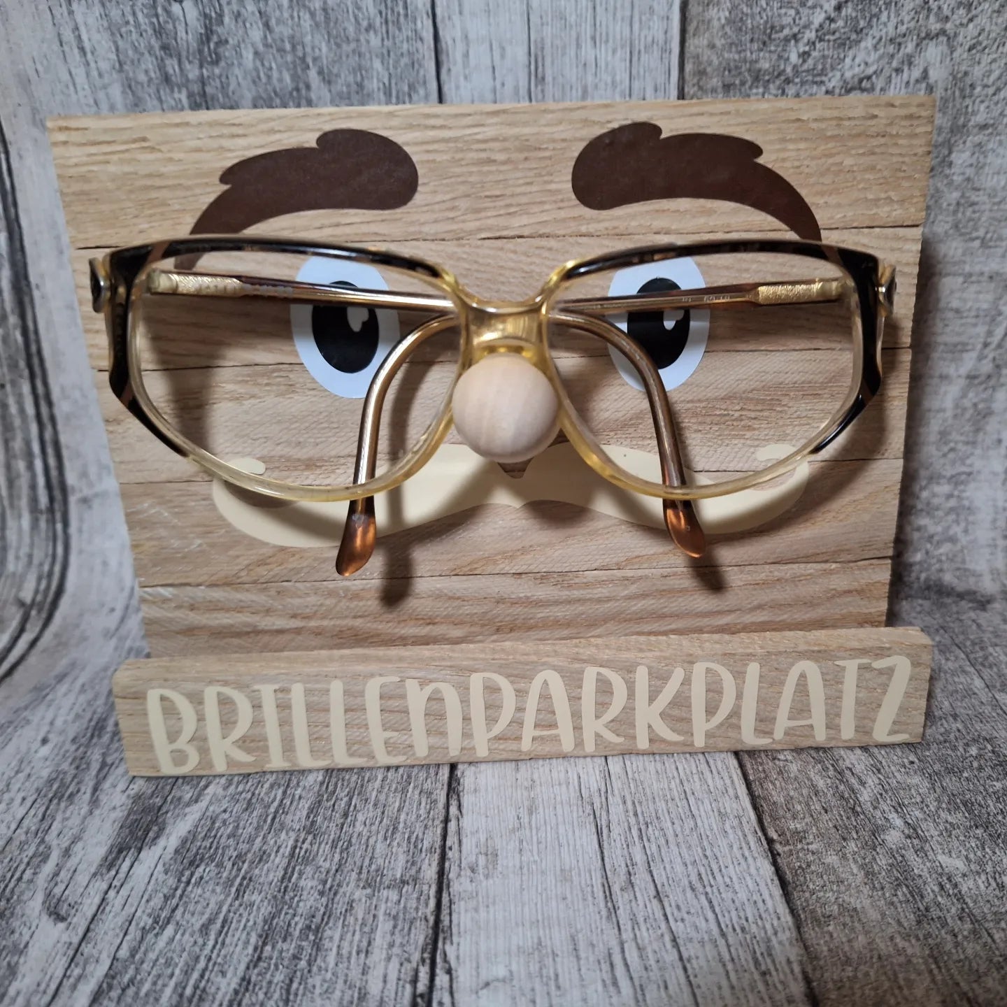 Niedlicher Holz-Brillenparkplatz mit Gesicht, ideal zur praktischen und dekorativen Aufbewahrung von Brillen.