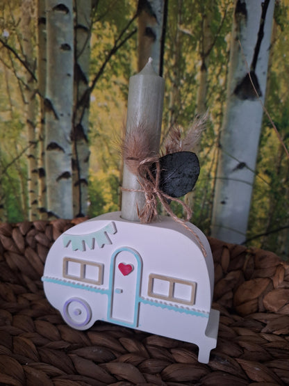 ntdecke diesen charmanten Camper aus Keraflott, liebevoll gegossen und mit zarten Pastellfarben akzentuiert. Das detailreiche Design verleiht deinem Innenraum eine verspielte und gemütliche Atmosphäre. Ob als dekoratives Highlight auf dem Tisch oder im Regal – der Camper ist mit einer vorgesehenen Öffnung versehen, in die eine Stabkerze gesteckt werden kann, um für stimmungsvolles Licht zu sorgen. Ein kleiner Trockenblumenstrauß rundet das Set ab und macht es zu einer besonderen Dekoration für dein Zuhause.
