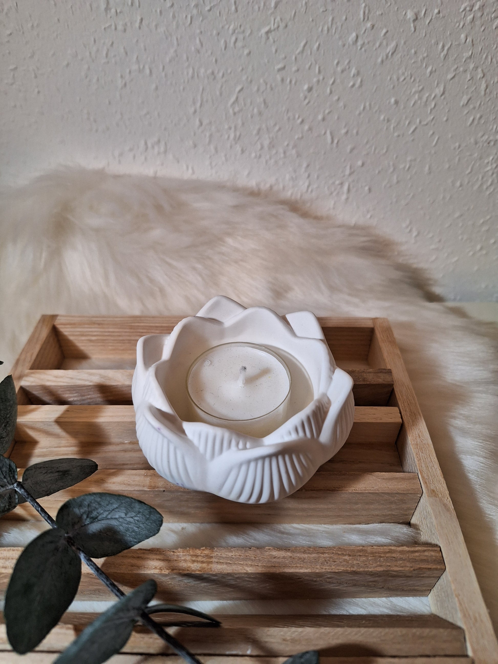 Ein aus Keraflott gegossener  weißer Teelichhalter in Form einer Lotusblüte 