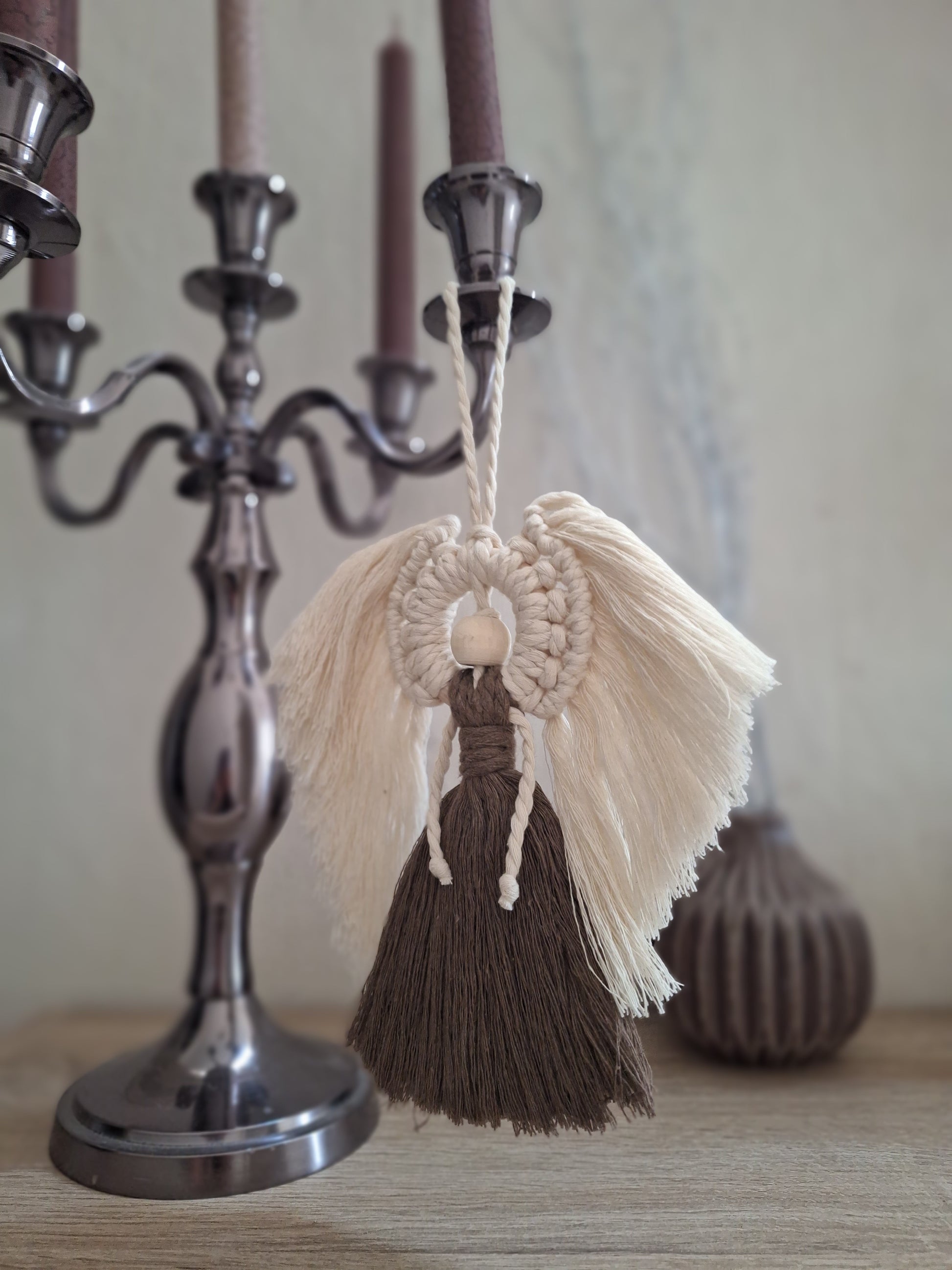 Handgemachter Makramee Engel zum Hängen, dekorativ im Boho-Stil, aus hochwertigem Makrameegarn, ideal für Wand, Fenster oder Tür, bringt eine friedliche und spirituelle Atmosphäre in den Raum. Die Flügel sind in beige und der Körper in dunkelbraun. Der Kopf ist aus einer Holzkugel.