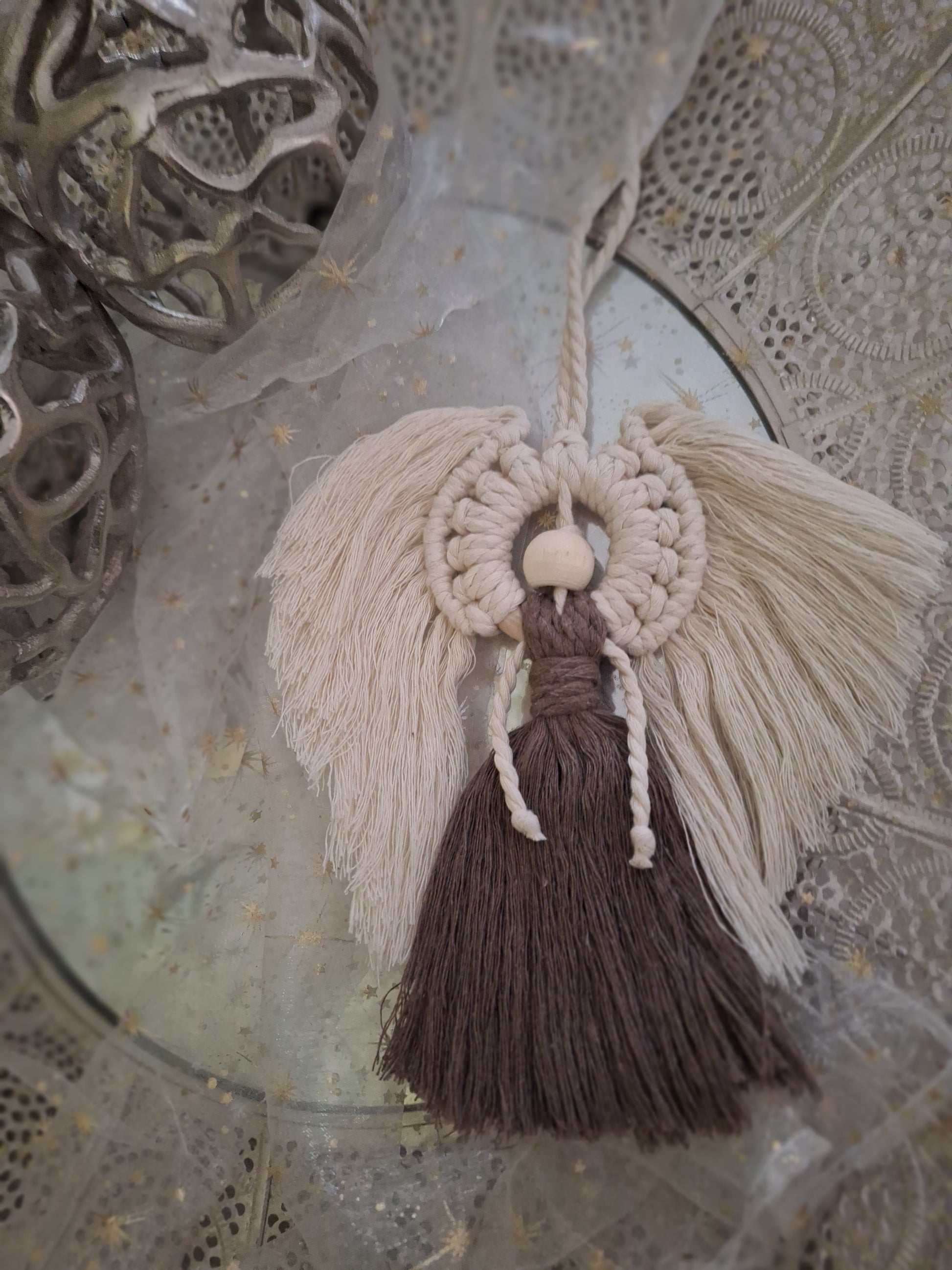 Handgemachter Makramee Engel zum Hängen, dekorativ im Boho-Stil, aus hochwertigem Makrameegarn, ideal für Wand, Fenster oder Tür, bringt eine friedliche und spirituelle Atmosphäre in den Raum. Die Flügel sind in beige und der Körper in dunkelbraun. Der Kopf ist aus einer Holzkugel.