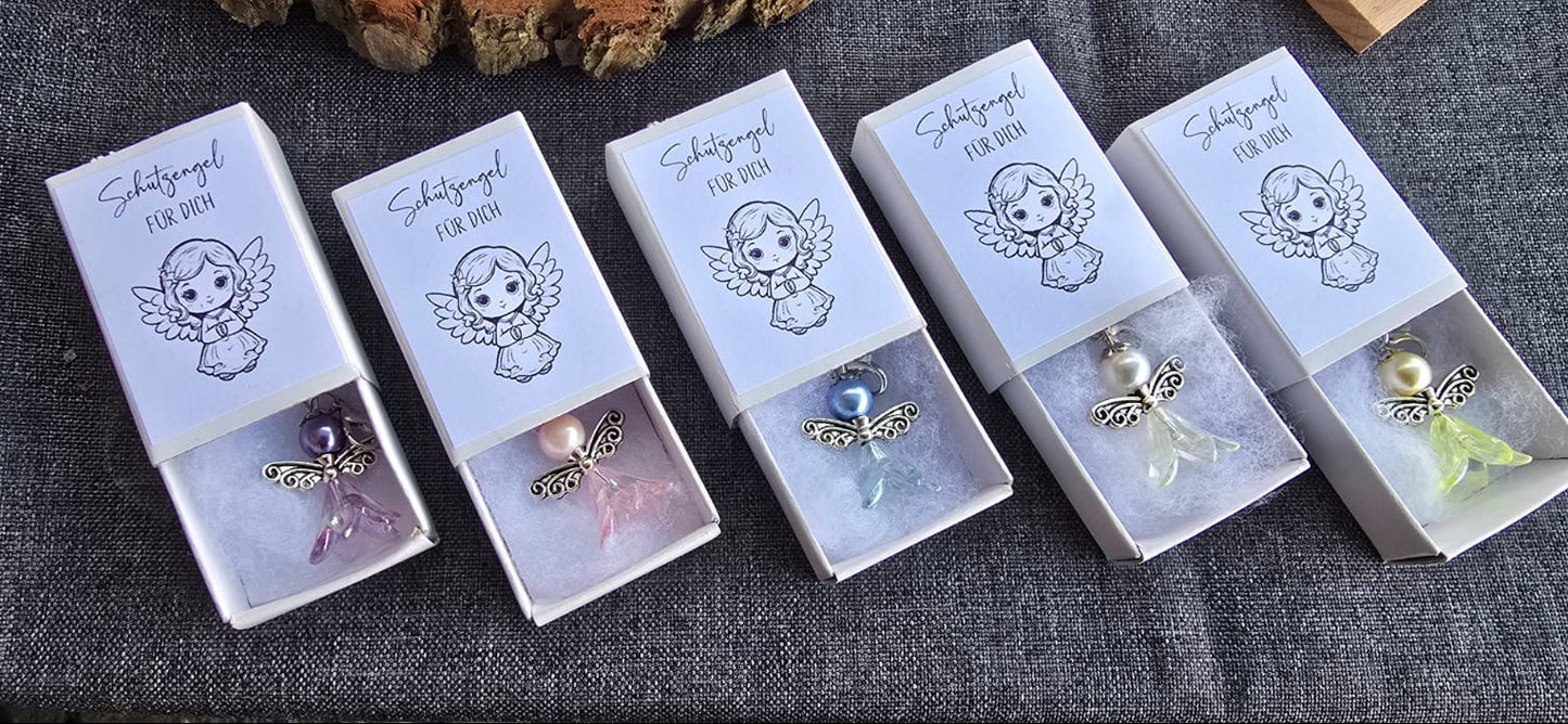 Kleiner Schutzengelanhänger gefertigt aus Perlen. Liegt in einer kleinen Schachtel gebettet auf Watte. Auf der Schachtel ist ein Aufkleber mit dem Spruch "Schutzengel für dich" und einem Bild eines kleinen Engelmädchens. Farben:lila, rosa, blau, gelb,weiß