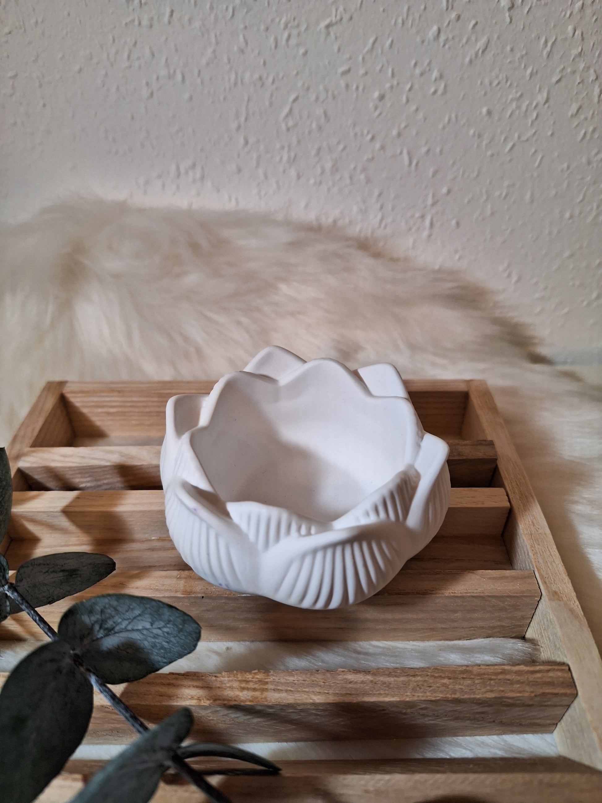 Ein aus Keraflott gegossener  weißer Teelichhalter in Form einer Lotusblüte 
